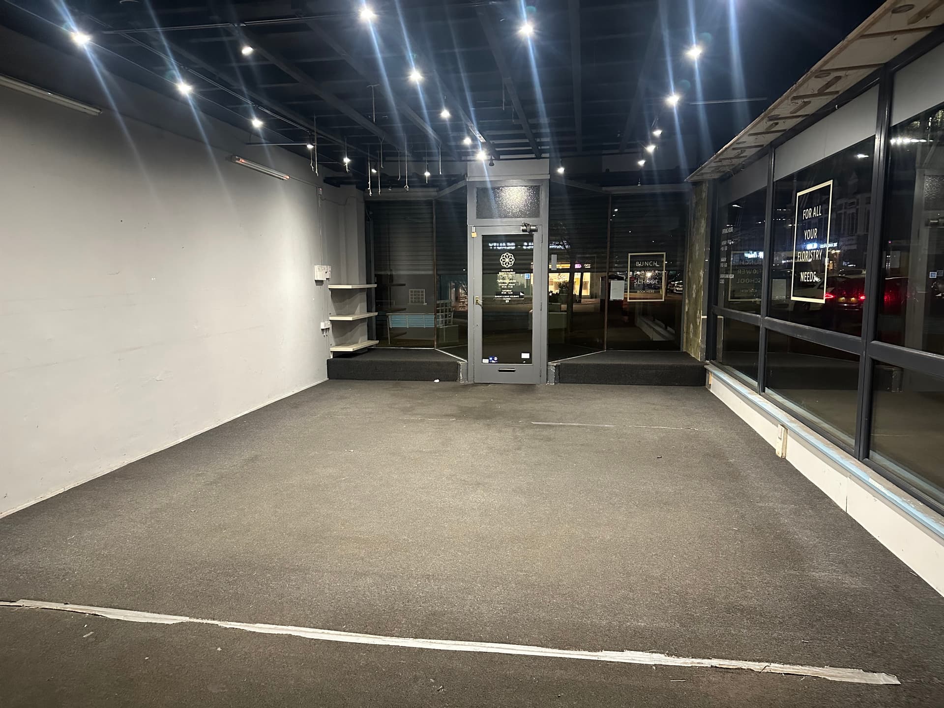 The empty, stripped-back commercial unit before renovation work began, with bare ceiling containment and no fit-out