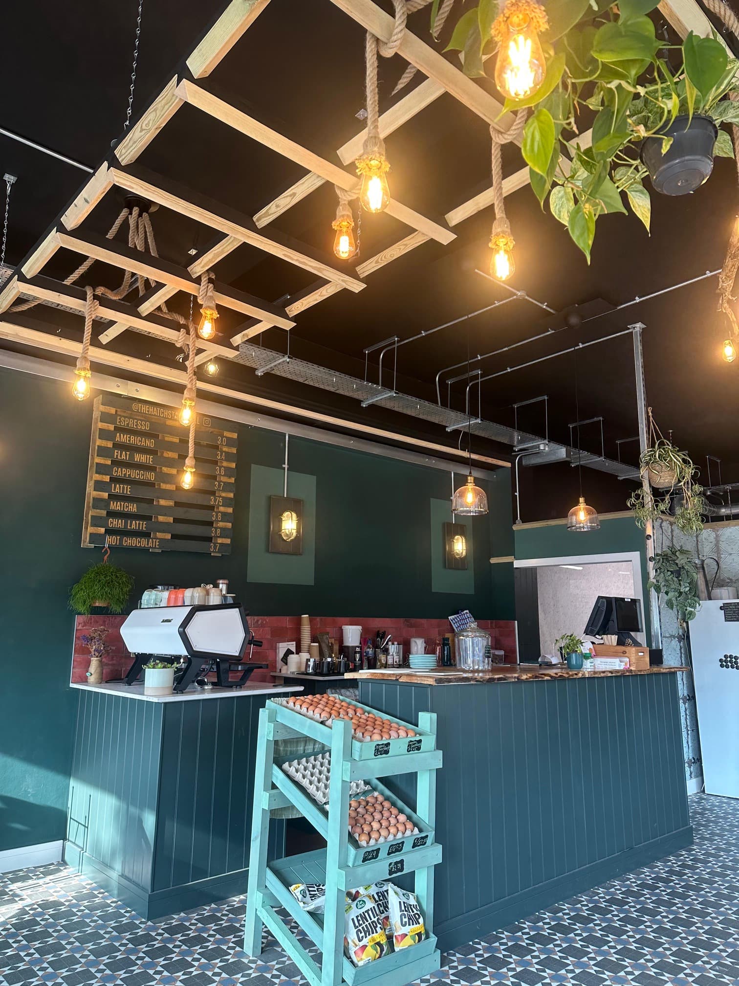 The finished coffee shop interior with feature lighting, menu board and seating